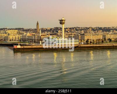 Le Havre, Francia, Europa - 16 gennaio 2025: Ingresso al porto di le Havre con la torre di controllo delle navi sul lungomare all'alba. Foto Stock