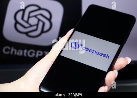 DeepSeek ai sullo schermo dello smartphone con mano femminile e logo ChatGPT sul display del computer Foto Stock