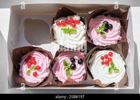 Scatola di sei Cupcake con glassa rosa e bianca. Primo piano. Foto Stock