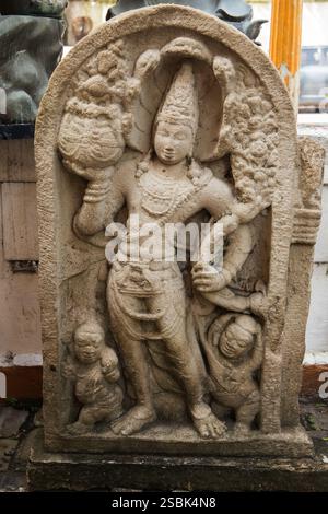 Antica statua in pietra al tempio Gangaramaya. Questo è uno dei templi più importanti di Colombo, Sri Lanka. Fotografia verticale Foto Stock