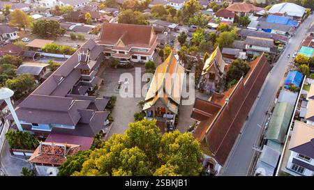 Splendida prospettiva aerea di Wat San Khue, un vibrante tempio buddista a Chiang mai, Thailandia, immerso nel caldo bagliore del sole che tramonta Foto Stock