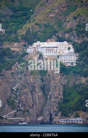 Il Grand Hotel Tritone è un hotel 4 stelle a Praiano, vicino ad Amalfi e Positano sulla Costiera Amalfitana. L'hotel dispone di una spiaggia privata e di camere con vista mare. Vista da una barca di passaggio. Praiano è un comune della provincia di Salerno, nella regione Campania del sud-ovest dell'Italia. Si trova sulla Costiera Amalfitana Foto Stock