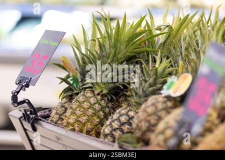Offerta di ananas con prezzo in un supermercato Foto Stock