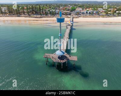 Vista aerea di un faro alla fine di un lungo molo sopra un mare calmo a Brighton, ad Adelaide, Australia meridionale. Foto Stock