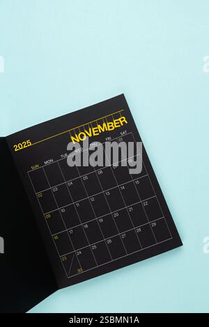 Novembre 2025 apertura calendario nero su sfondo blu. Foto Stock