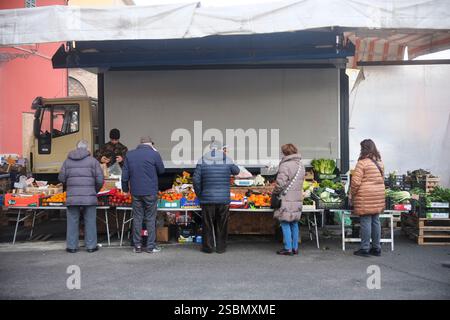 Busseto, Parma, Italia - 31 gennaio 2025 fruttivendolo che vende prodotti stagionali ai clienti durante il mercato settimanale di Busseto a Parma, Italia Foto Stock