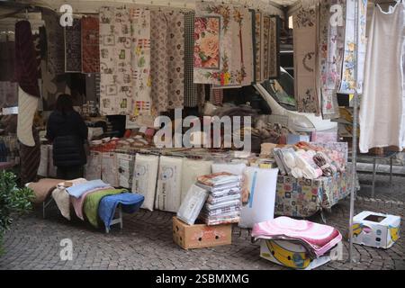 Busseto, Parma, Italia - 31 gennaio 2025 venditrice ambulante di tessuti per la casa in una stalla a Busseto mercato settimanale, vicino Parma, Italia Foto Stock