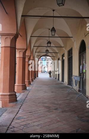 Busseto, Parma, Italia - 31 gennaio 2025 portico vuoto con colonne e lampade che illuminano il pavimento in mattoni a Busseto, Parma, Italia Foto Stock