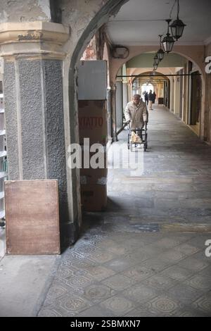 Busseto, Parma, Italia - 31 gennaio 2025 uomo anziano che cammina con un camminatore per le affascinanti strade di Busseto, Parma, Italia, godendosi il vibraio Foto Stock
