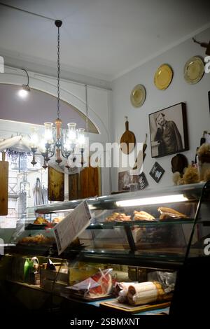 Busseto, Parma, Italia - 31 gennaio 2025 vetrina con vari prodotti gastronomici, lampadario appeso e ritratto di Giuseppe Verdi, famoso i Foto Stock