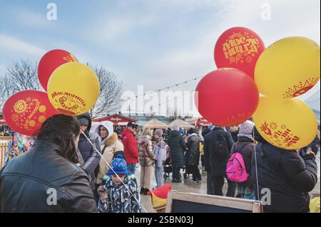 Kolomna, Russia, 17 marzo 2024. Maslenitsa. Le persone con palloncini con l'iscrizione Maslenitsa camminano a una fiera in un giorno di festa. Le vacanze della gente. T Foto Stock