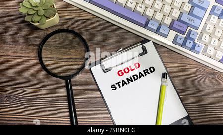 Concetto di Gold Standard scrivere su documenti cartacei isolati su un tavolo di legno. Foto Stock
