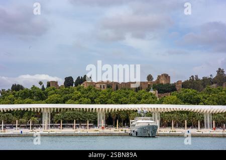 Una vista sul Paseo Muelle uno con la fortezza di Alcazaba a Malaga, Spagna Foto Stock