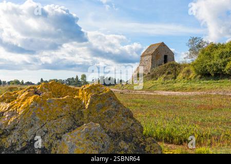 Corpse de Garde, casa di guardia medievale a Saint-Germain-Sur-Ay, affacciata sulla palude salata. Una grande roccia in primo piano. Foto Stock