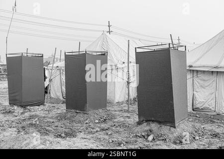 La latrina di nuova costruzione si erge fuori dalle tende di Kumbh Mela, garantendo servizi igienici essenziali per i pellegrini in mezzo al grande raduno. Foto Stock