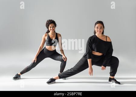 Due donne si impegnano in una potente routine di fitness, dimostrando forza e concentrazione durante la pratica. Foto Stock