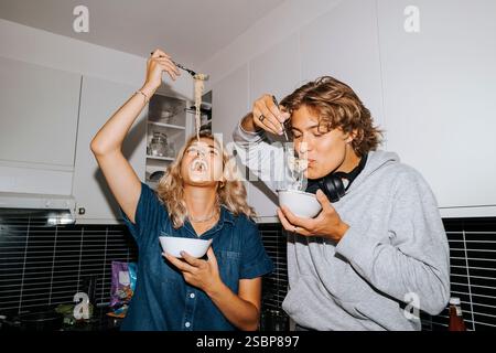 Giovani amici del college e ragazze mangiano spaghetti nella cucina del dormitorio del college Foto Stock