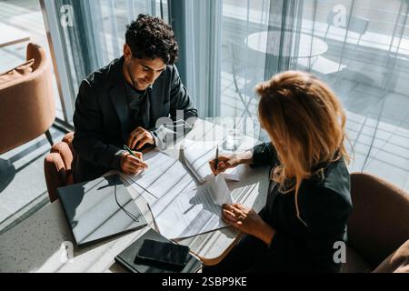 Vista dall'alto della donna d'affari che lavora con un cliente mentre si trova alla scrivania in ufficio Foto Stock