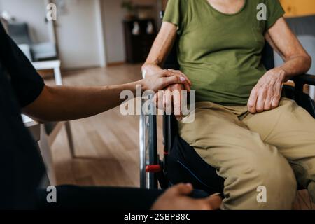 A metà di una donna anziana che viene consolata dall'infermiere a casa di cura Foto Stock