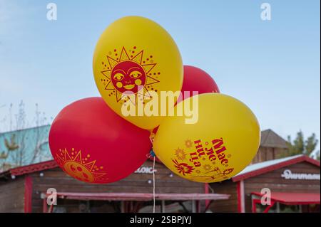 Kolomna, Russia, 17 marzo 2024. Maslenitsa. Le persone con palloncini con l'iscrizione Maslenitsa camminano a una fiera in un giorno di festa. Le vacanze della gente. T Foto Stock