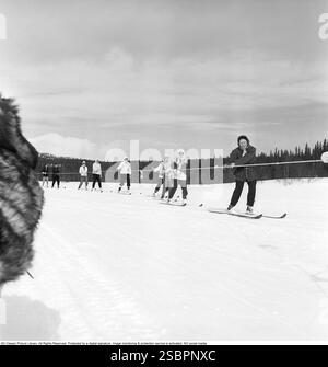 Åre 1952. Popolare località di sport invernali a Jämtland in Svezia, dove la gente va a sciare e socializzare. Åre è conosciuta per la sua lunga storia di sci e gli anni '1950 erano un periodo in cui lo sci era un'attrazione sportiva e turistica in crescita. La foto mostra le persone che partecipano ad attività invernali come sciare dietro una motoslitta, essere trainate a bassa velocità attraverso la selvaggia. Fotografo: Svahn Foto Stock