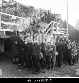 Åre 1952. Popolare località di sport invernali a Jämtland in Svezia, dove la gente va a sciare e socializzare. Åre è conosciuta per la sua lunga storia di sci e gli anni '1950 erano un periodo in cui lo sci era un'attrazione sportiva e turistica in crescita. La foto viene scattata durante il giorno della cerimonia di apertura dello skilift di Åre il 5 aprile 1952. Il Direttore generale delle Ferrovie statali svedesi SJ ha parlato all'inaugurazione. È stato il primo impianto di risalita di Åre e la gente fa la fila per provarlo. Foto Stock