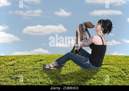 Bella giovane donna con il suo cucciolo di pit Bull Foto Stock