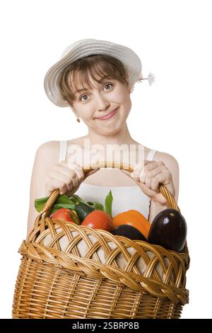 Ragazza che tiene un cestino di deliziose verdure fresche Foto Stock