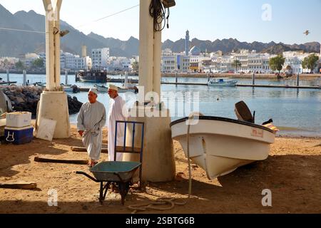 MUTTRAH, MASCATE, OMAN - 27 DICEMBRE 2024: La Corniche di Muttrah vista dal porto ittico (accanto al mercato del pesce), con barche da pesca Foto Stock