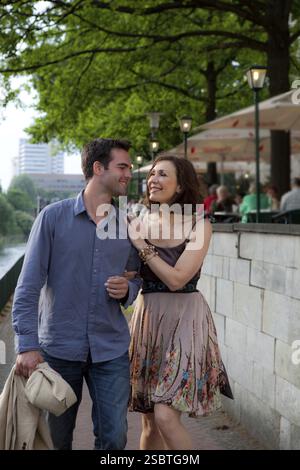 Coppia felice che cammina per una strada e abbraccia Foto Stock