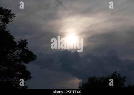 Nuvole di pioggia in contrasto con il sole alla fine della giornata. Foto Stock