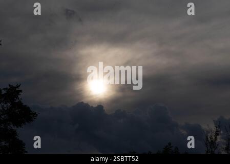 Nuvole di pioggia in contrasto con il sole alla fine della giornata. Foto Stock