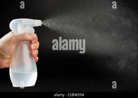 Barbiere spray liquido alcolico dal flacone nella vista laterale Foto Stock