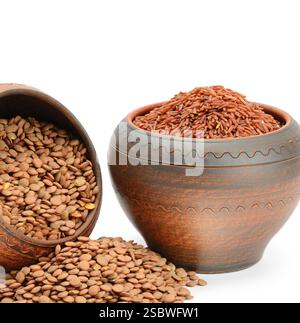 Lenticchie e riso integrale in vasi di argilla isolati su fondo bianco. Cibo vegetariano nutriente. Foto Stock