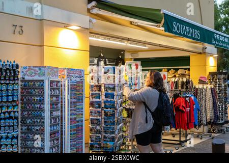 Sirmione, Italia - 21 settembre 2024: Una donna che sfoglia cartoline e souvenir in un negozio di articoli da regalo nel centro storico di Sirmione Foto Stock