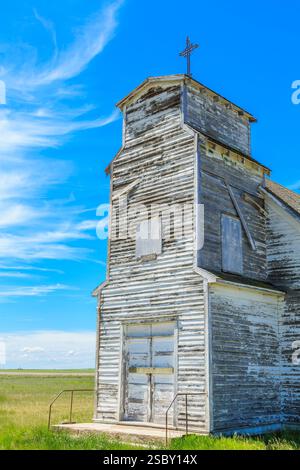 Piccola chiesa con una croce in cima. L'edificio è vecchio e ha molto legno Foto Stock