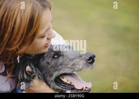 Primo piano di una donna che mostra affetto a un cane, catturando un momento di legame Foto Stock