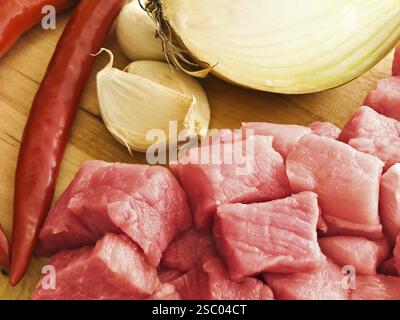 Pezzi di carne con pepe, aglio e cipolla su un pannello rigido Foto Stock