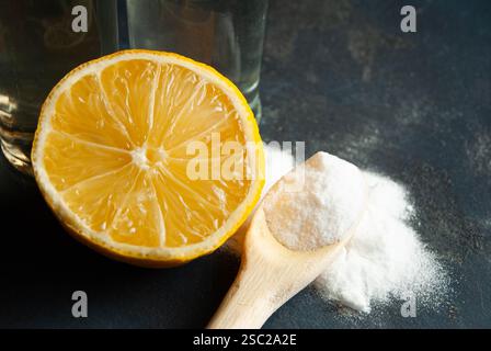 Una disposizione ben composta di ingredienti naturali per la pulizia e la salute, tra cui bicarbonato, limone fresco, aceto e sidro di mele, posizionato su un vibr Foto Stock