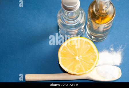 Una disposizione ben composta di ingredienti naturali per la pulizia e la salute, tra cui bicarbonato, limone fresco, aceto e sidro di mele, posizionato su un vibr Foto Stock