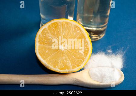 Una disposizione ben composta di ingredienti naturali per la pulizia e la salute, tra cui bicarbonato, limone fresco, aceto e sidro di mele, posizionato su un vibr Foto Stock