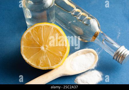 Una disposizione ben composta di ingredienti naturali per la pulizia e la salute, tra cui bicarbonato, limone fresco, aceto e sidro di mele, posizionato su un vibr Foto Stock
