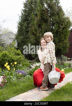 Festa della mamma, compleanno. Felice maternità e infanzia. un figlio e una madre carini che si abbracciano e si rallegrano, buon umore. L'atmosfera dell'amore di famiglia, tendini Foto Stock