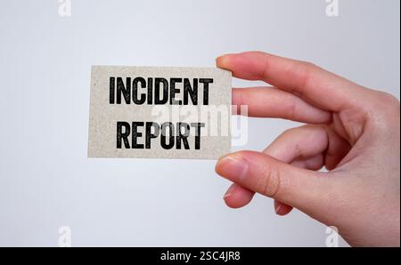 Messaggio di segnalazione incidente scritto su una scheda in mano. Simbolo del rapporto sull'incidente concettuale. Copia spazio. Foto Stock