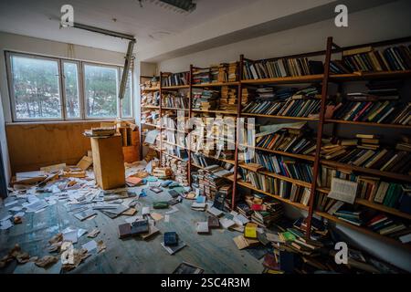 Vecchi libri sugli scaffali nell'armadietto della biblioteca abbandonata. Foto Stock