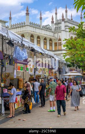 Turisti e gente del posto attratti dalle bancarelle alimentari di Ramadhan in Muscat Street a Singapore all'ombra della Moschea del Sultano, punto di riferimento religioso di Kampong Glam Foto Stock