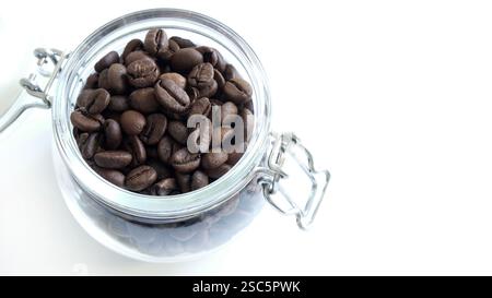 Chicchi di caffè in un vaso di vetro isolato su sfondo bianco. Copia spazio. Direttamente sopra. Foto Stock