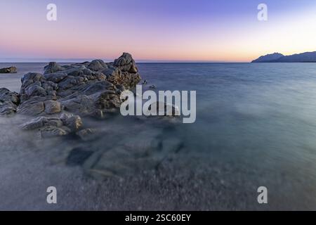 Scogli nel mare sulla spiaggia di Torre di Bari al tramonto, lunga esposizione, Torre di Bari, Bari Sardo, Ogliastra, Sardegna, Italia, Europa Foto Stock