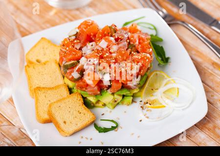 Bistecca fresca di tartare di salmone con avocado e pane secco Foto Stock