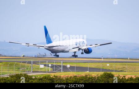 Auckland, nuova Zelanda – 1 febbraio 2025: United Airlines N788UA Boeing 777-222(ER) atterrando con le ruote in atterraggio sulla pista e producendo fumi di pneumatici. Foto Stock